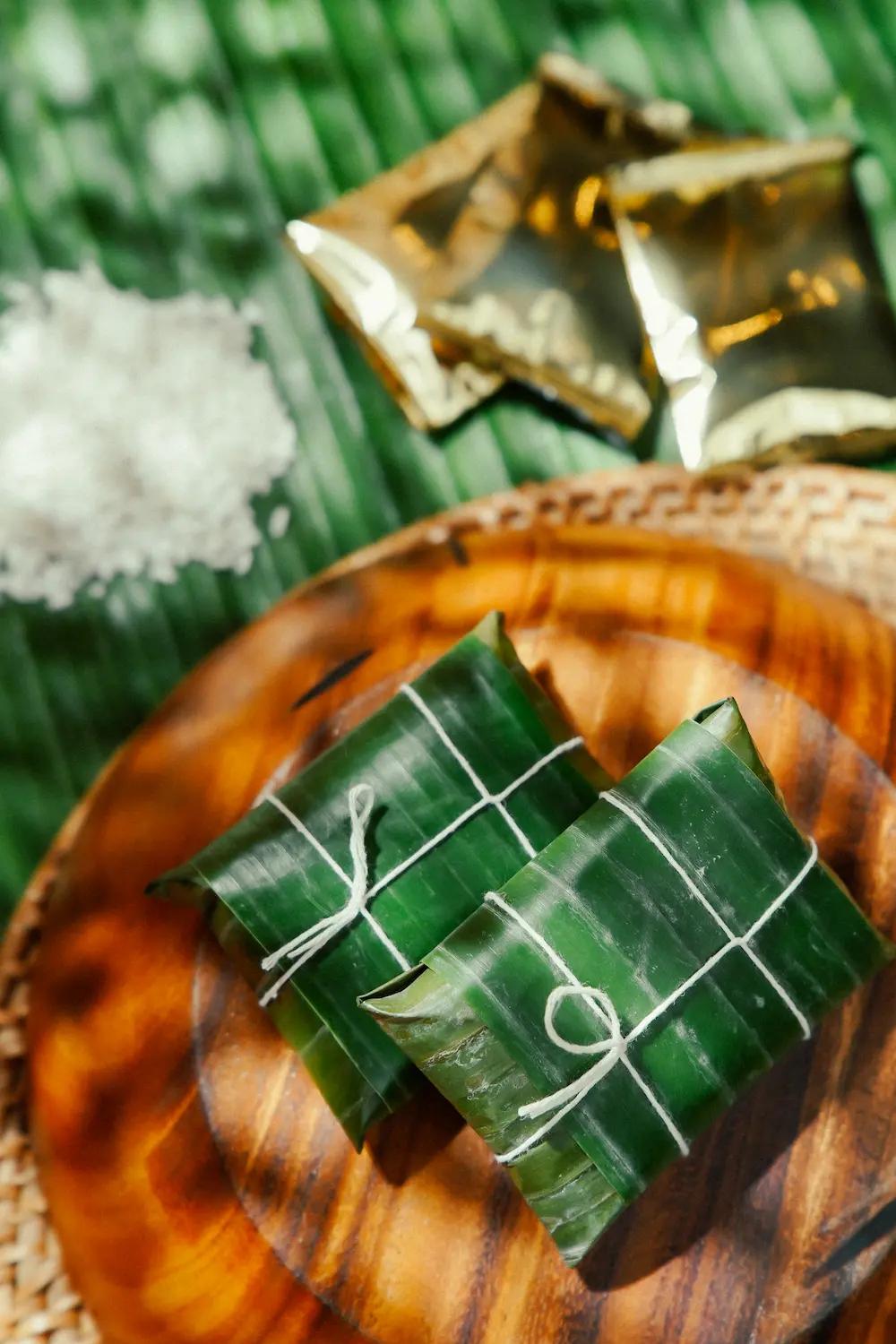 A Table containing Filipino rice cakes wrapped in banana leaves