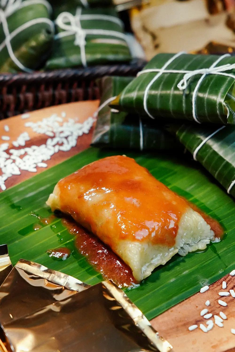 A Table containing Filipino rice cakes wrapped in banana leaves