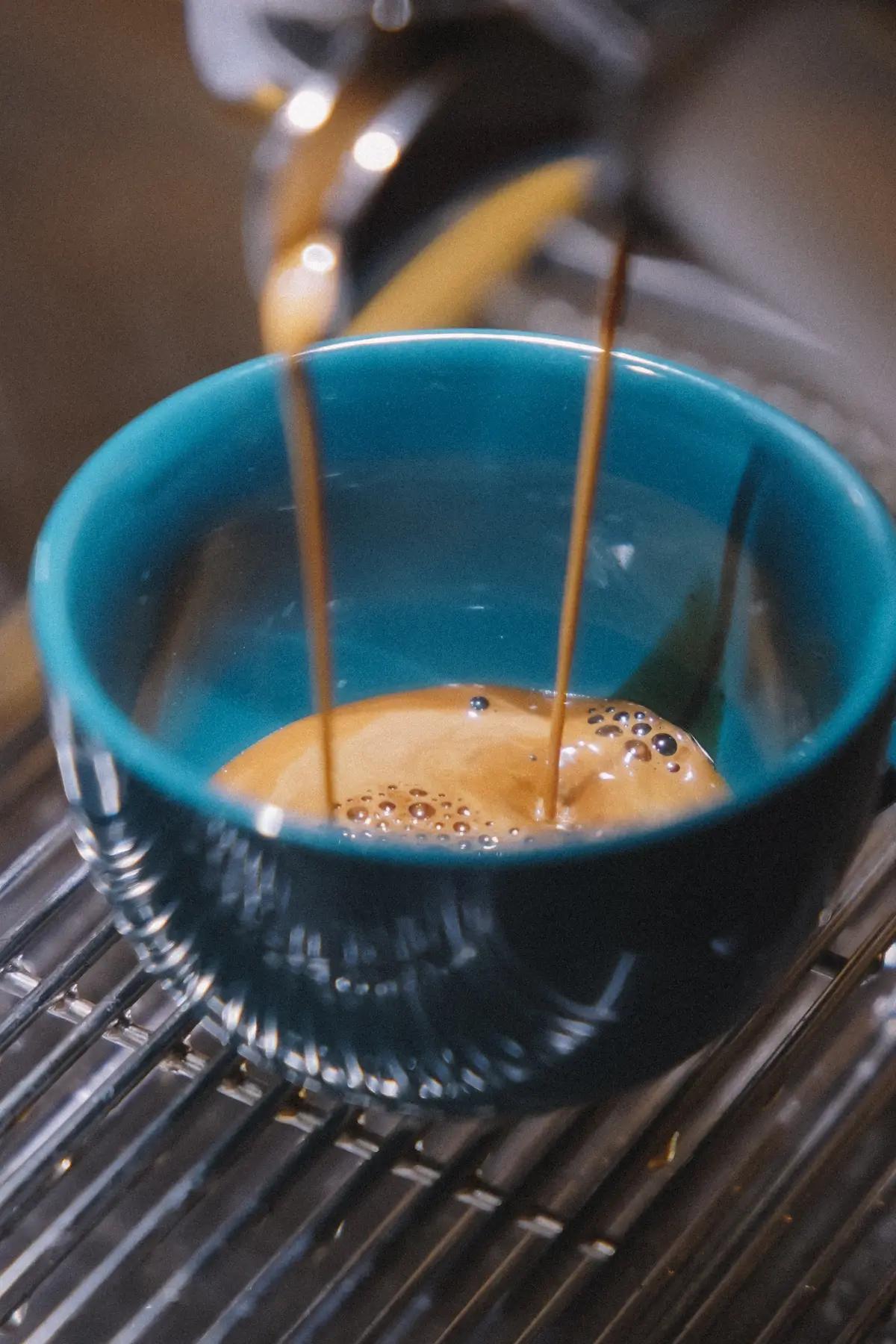 A coffee cup being filled up with fresh coffee