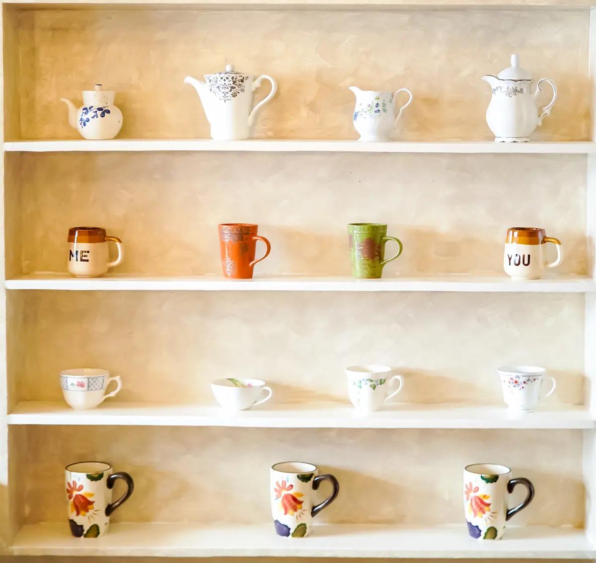 A shelf of assorted tea mugs